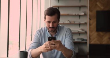 Mobil zaferi kutlayan neşeli, coşkulu, genç, beyaz bir adam..