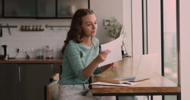 Attractive young caucasian woman reading paper correspondence. — Stock Video