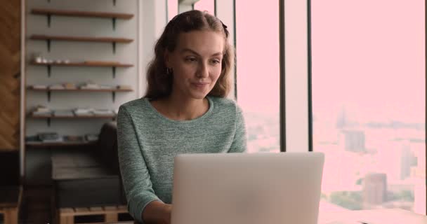 Sonriente milenaria hermosa mujer trabajando en la computadora en la oficina. — Vídeos de Stock