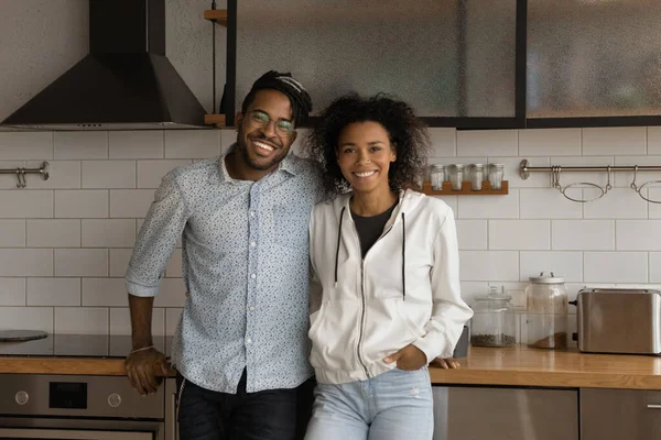 Alegre joven africano familia pareja abrazo en elegante casa cocina —  Fotos de Stock