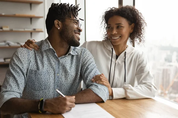 Felici coniugi neri si sostengono a vicenda nella firma del contratto — Foto Stock