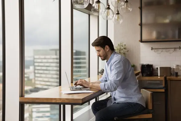 Concentré jeune homme moderne conçu propriétaire d'appartement studio en utilisant un ordinateur portable — Photo
