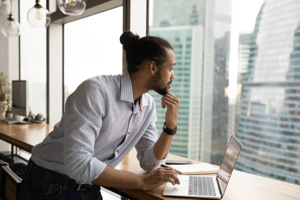 Pensive young black man rest from computer by panoramic window — Stock Photo, Image