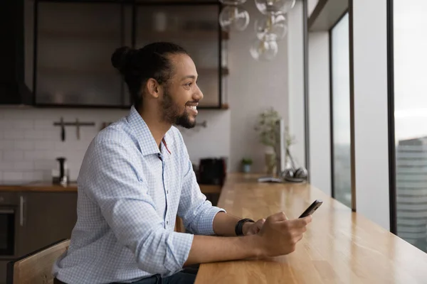 Positive black male renter of apartment dream distracted from cell — Stock Photo, Image