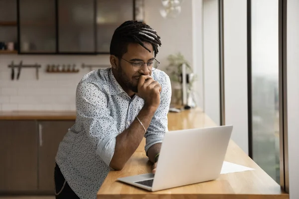 Smiling black guy freelancer read good message on laptop screen