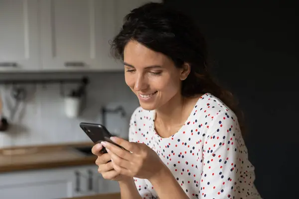 Mujer sonriente utilizar mensajes de texto de teléfonos celulares en línea en gadget — Foto de Stock