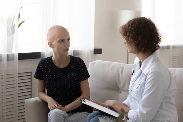 Arzt spricht bei Sprechstunde mit haarloser Krebspatientin — Stockfoto