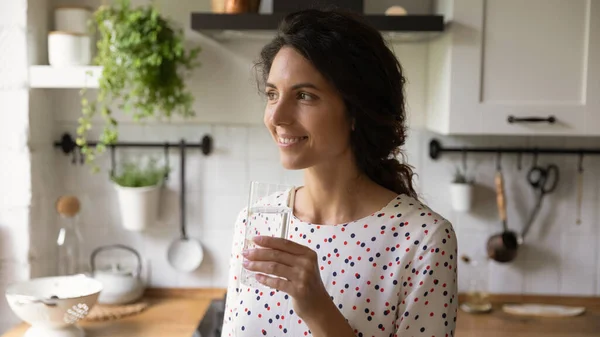 Счастливая женщина пьет минеральную воду дома — стоковое фото