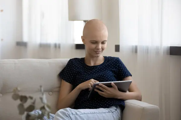 Улыбающаяся женщина с раком расслабиться с помощью таблетки — стоковое фото