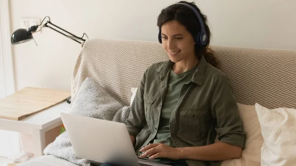 Happy woman in earphones watch webinar on laptop — Stock Photo, Image