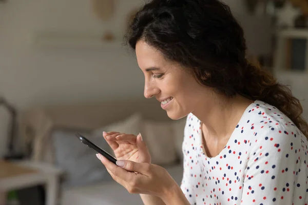 Mujer sonriente usando la mensajería moderna de teléfonos inteligentes en línea — Foto de Stock