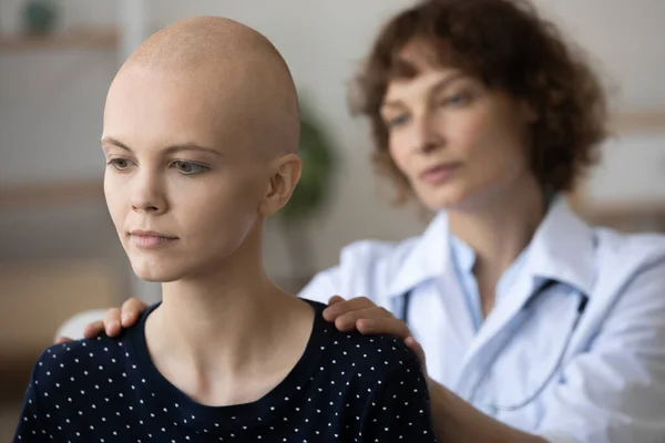 Pflegende Krankenschwester tröstet junge Krebspatientin — Stockfoto