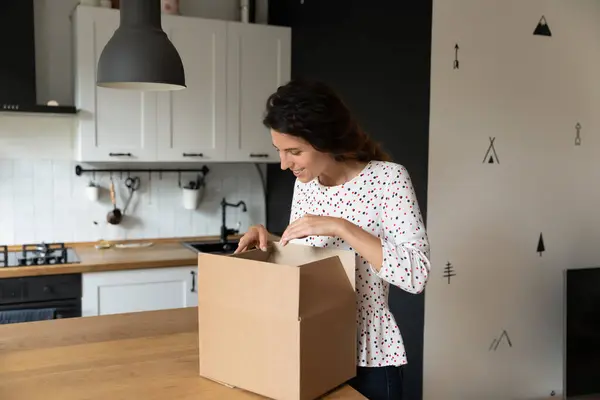 Mujer excitada desempacar caja con pedido por Internet —  Fotos de Stock