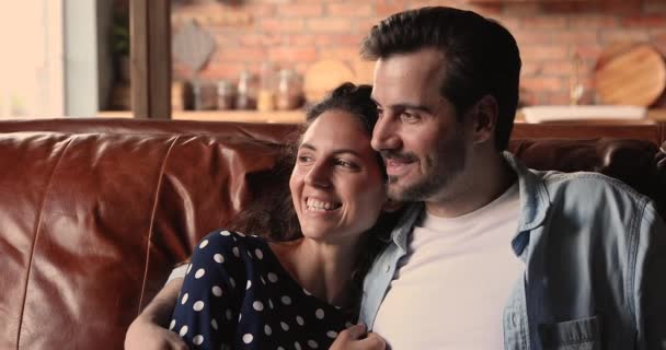 Milující pár sedí na pohovce mluví daydreaming při pohledu do dálky — Stock video