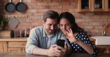 Mutlu çift akıllı telefondan SMS okuyarak online kumarhane zaferini kutluyor.