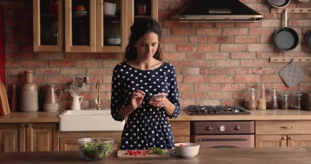 Mujer sosteniendo teléfono inteligente buscar recetas de comida vegetariana saludable en Internet — Vídeos de Stock