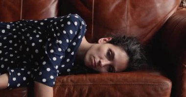 Kanepeye düşmüş yorgun bir kadın.