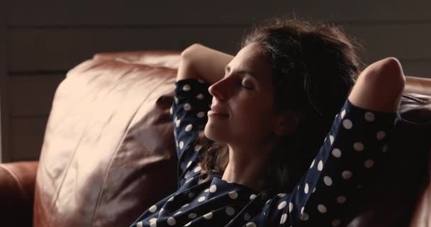 Mujer serena poner las manos detrás de la cabeza relajarse solo en el sofá — Vídeo de stock