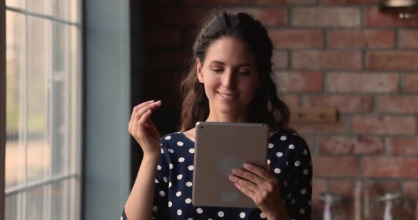 Jovem atraente comprando na internet usando dispositivo sem fio tablet — Vídeo de Stock