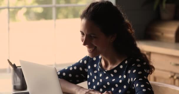 Gülümseyen kadın video konferans uygulaması ile konuşan dizüstü bilgisayar kullanıyor — Stok video