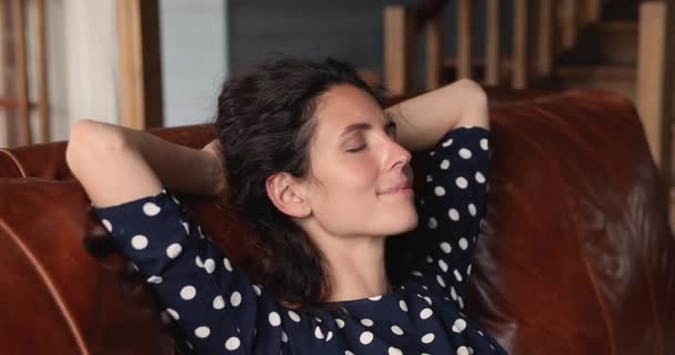 Békés nő tegye a kezét a feje mögé, pihenjen egyedül a kanapén. — Stock videók