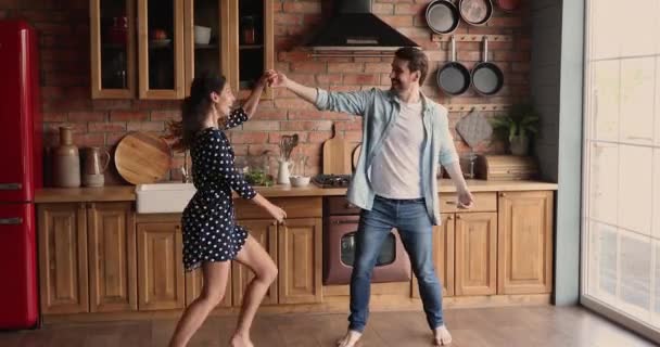 Grappig actief jong paar in liefde dansen in de keuken — Stockvideo