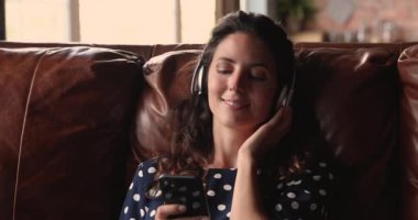 Kulaklıklı kadın kaliteli müzik dinlemekten hoşlanır. Akıllı telefon kullanın.