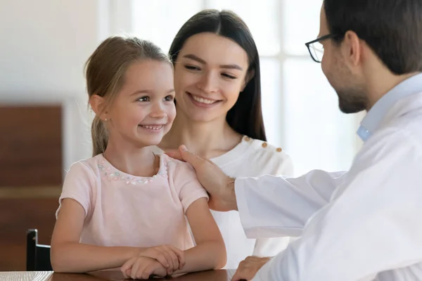 Male doctor cheer small girl patient at hospital consultation — Stock Photo, Image
