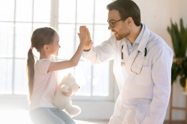 Mutlu erkek doktor küçük kız çocuğuyla iyi eğlenceler.
