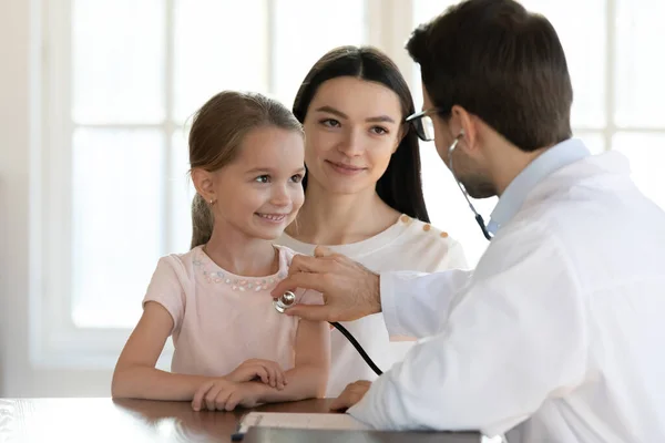 Caring male doctor listen to small child patient heart — Stock Photo, Image