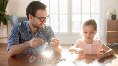 Sevgi dolu bir baba küçük kızıyla bilezik takar.