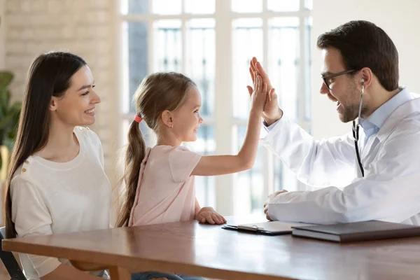 Smiling male doctor cheer small child patient in hospital — Stock Photo, Image