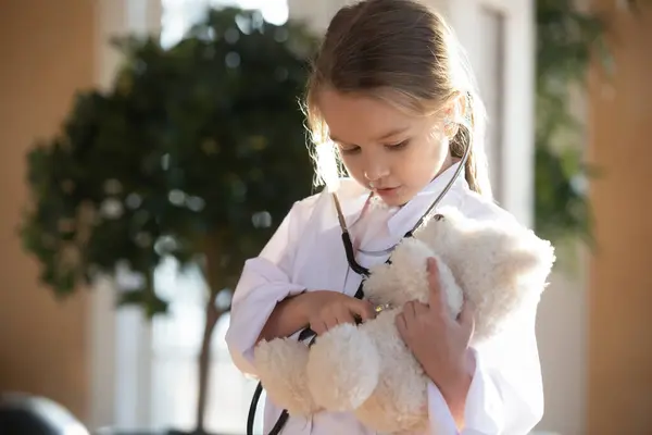Petite fille enfant agir comme médecin remède ours en peluche — Photo