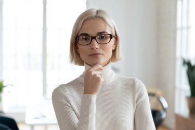 Modern ofiste poz veren ciddi bir iş liderinin resmi.