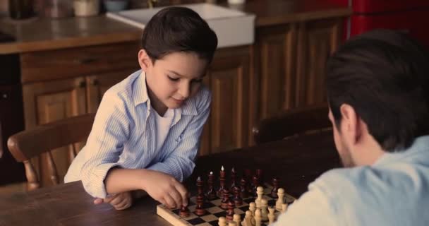 Маленький умный мальчик играет с папой в шахматы. — стоковое видео