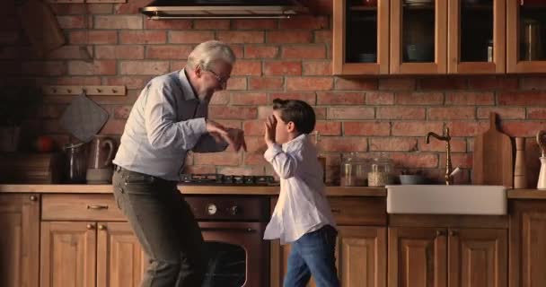 Enérgico abuelo de mediana edad bailando con su nieto pequeño. — Vídeo de stock