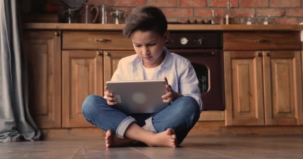 Gelukkig klein schattig jongen met behulp van touchpad thuis. — Stockvideo