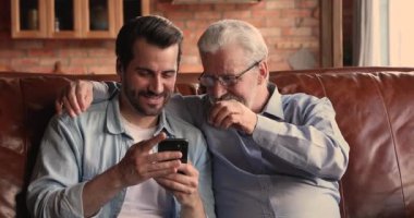 Evde akıllı telefon kullanan mutlu bir aile..