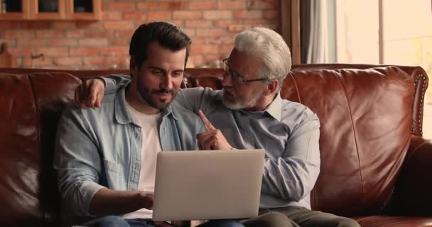 Happy to forskellige mandlige generationer familie have det sjovt ved hjælp af computer. – Stock-video