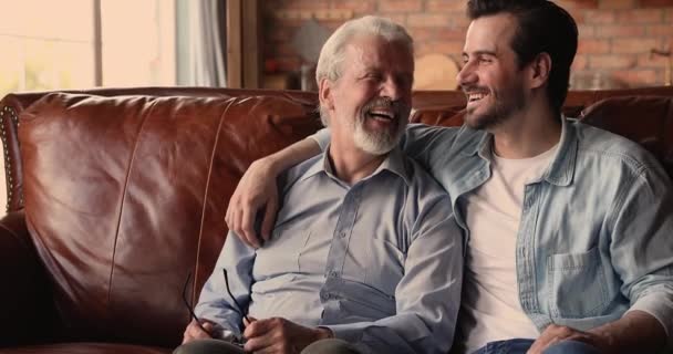 Marzycielski mężczyzna w średnim wieku i dorosły syn komunikują się w domu. — Wideo stockowe