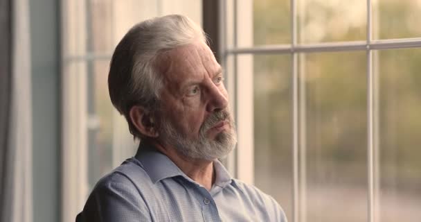 Старший гарячий 60-х чоловік у відставці дивиться з вікна . — стокове відео