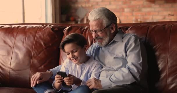 Famille multigénérationnelle profiter de jouer à un jeu en ligne sur téléphone cellulaire. — Video