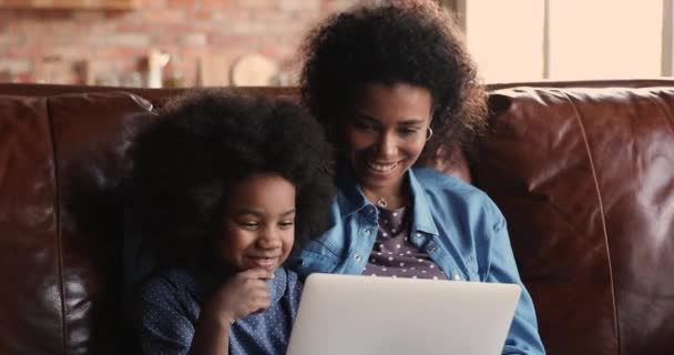 Glad liten afrikansk flicka som använder dator med mamma. — Stockvideo