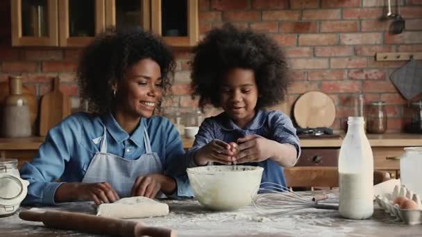 Leende afrikansk amerikansk kvinna njuter av matlagning med liten dotter. — Stockvideo