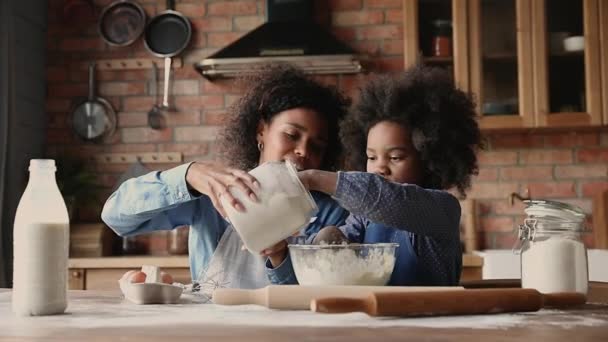 Kärleksfull afrikansk etnicitet ung mor hjälpa små dotter att tjäna pengar. — Stockvideo