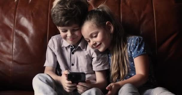 Feliz niños pequeños hermanos jugando en el teléfono inteligente. — Vídeo de stock