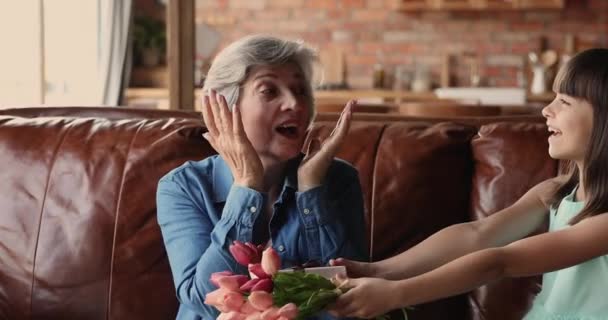 La abuela que recibe de la nieta las flores de tulipán — Vídeos de Stock