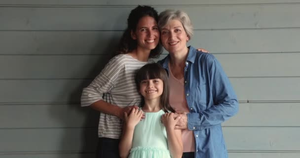 Три поколения женщин позируют обнимающимися в студии — стоковое видео