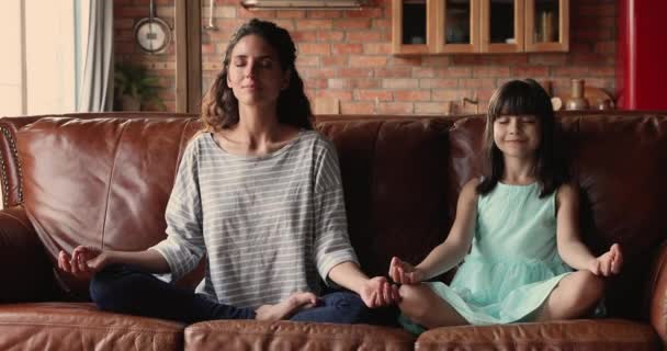 Young mom her daughter do meditation practice at home — Stock Video