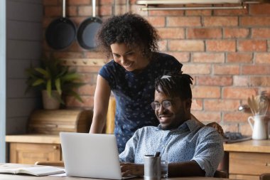 Birlikte dizüstü bilgisayar kullanan mutlu Afro-Amerikan çifti kapatın.